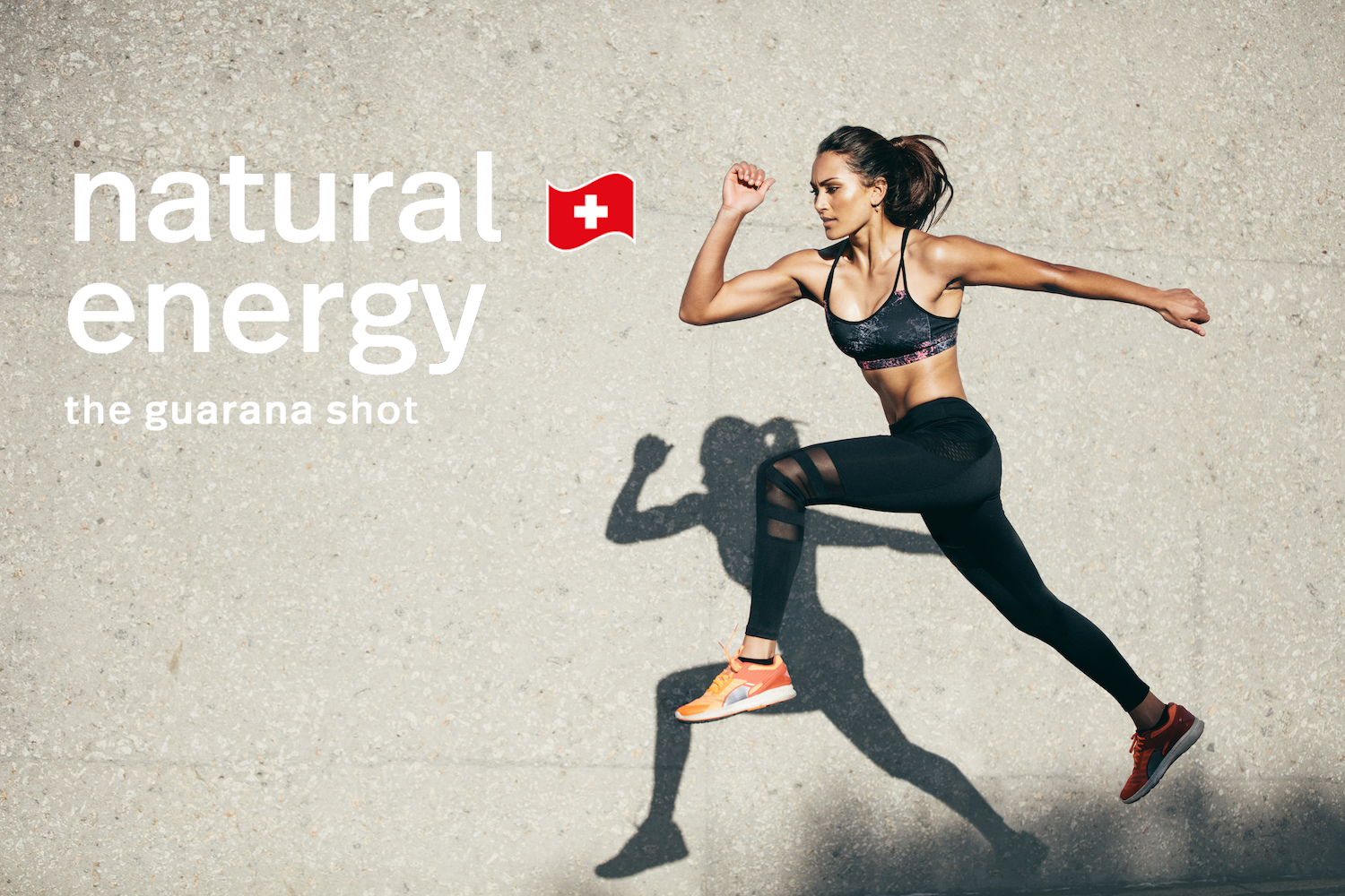 Woman running on a concrete surface with 'natural energy' and guarana shot branding.