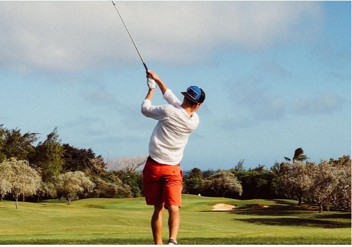 male swinging a golf club